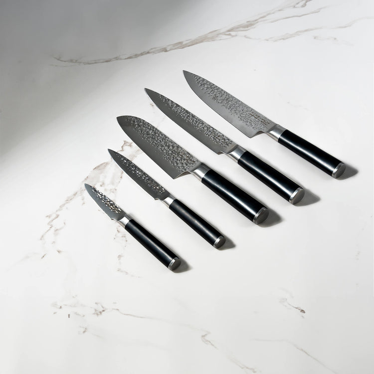 Swiss Diamond hammered 5-piece knife set with white marble handles, displayed on a white marble surface.