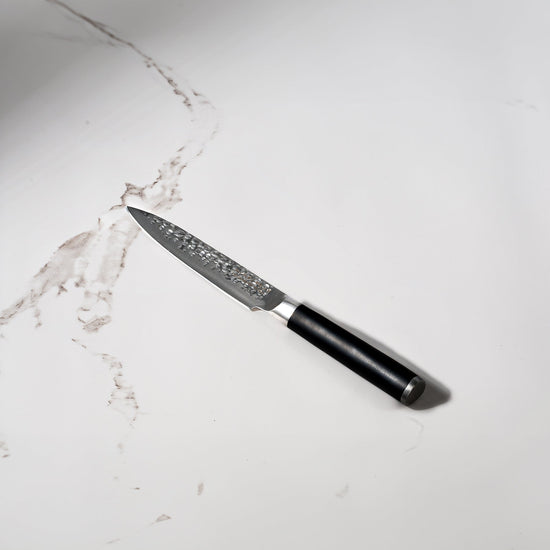 Swiss Diamond 5-inch hammered utility knife with a white marble handle, showcasing a sleek and durable kitchen knife design.