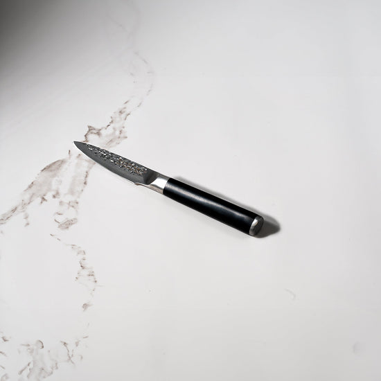Swiss Diamond 4-inch hammered paring knife with white marble handle, showcasing a sleek, precision-forged kitchen knife design.