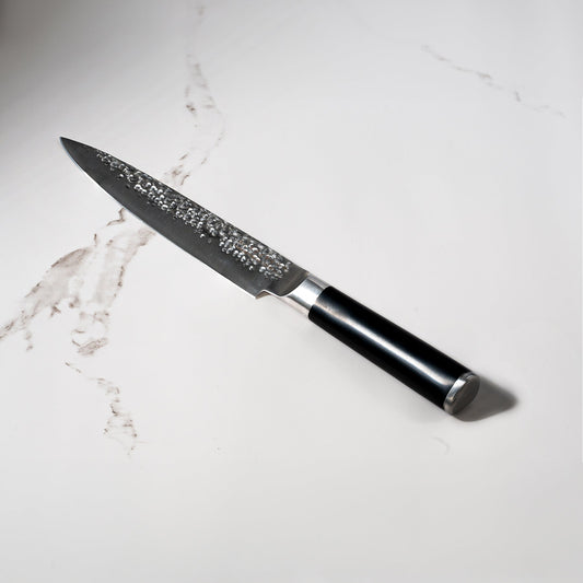 Swiss Diamond 8-inch hammered carving knife with a white marble handle and stainless steel blade for precise slicing.