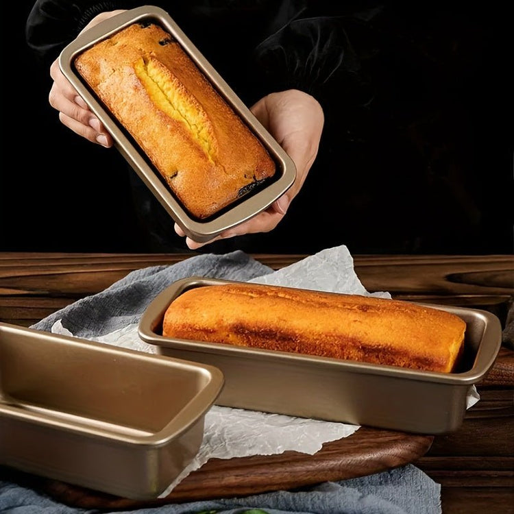 Loaf of bread in a baking pan held above a wooden surface with more loaves.