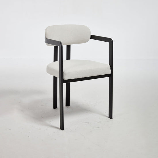 Set of two HouseOfZazla dining arm chairs with plush upholstery and wooden legs, ideal for modern dining rooms.