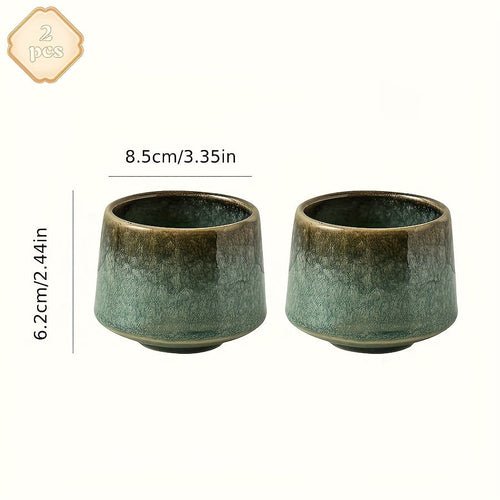Two green ceramic cups with dimensions on a white background