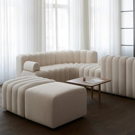 Modern off-white lamb velvet sectional sofa with curved design, plush cushions, and sleek contemporary style.