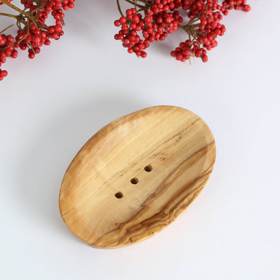 Wooden soap dish with natural grain on a white background with red berries