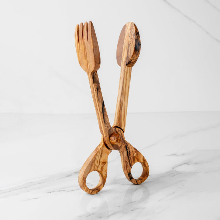 Wooden scissors with a fork and spoon design on a marble surface