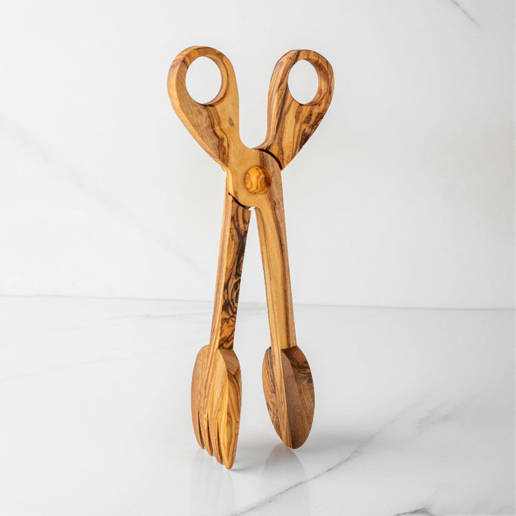 Wooden tongs on a white marble surface