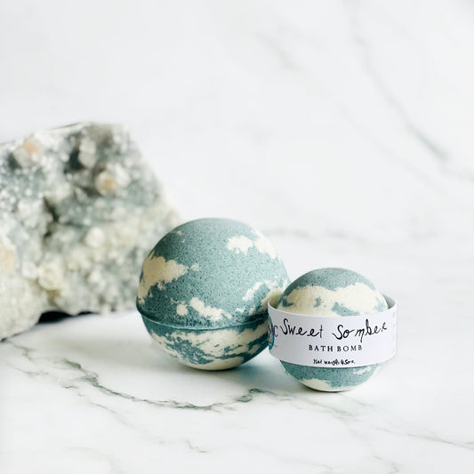 Two bath bombs with a label on a marble surface