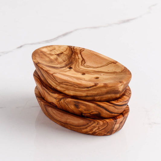 Stack of wooden soap dishes on a white background