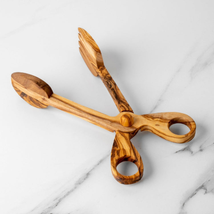 Wooden tongs on a marble surface