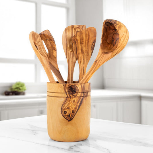 Set of wooden utensils in a wooden holder on a marble surface