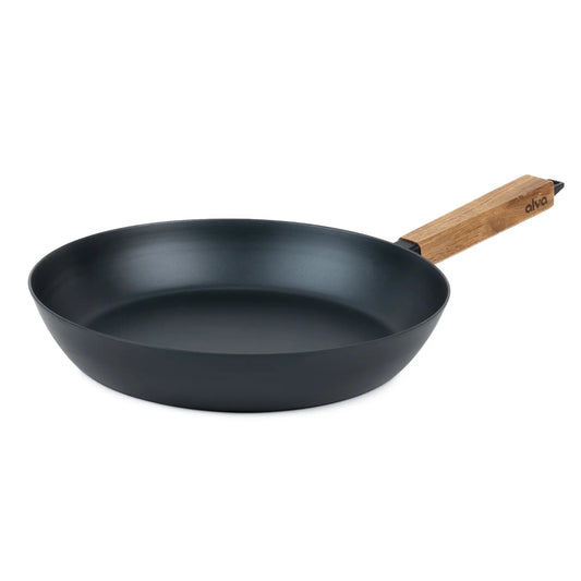 Alva Cookware frying pan with a smooth black non-stick surface and stainless steel handle on a wooden table.