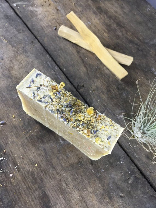 Bar of soap with natural ingredients on a wooden surface