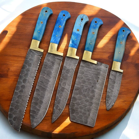 Handmade Damascus kitchen knives set with bone handles, showcasing polished blades and detailed craftsmanship.