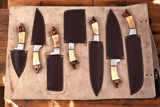 Handmade Damascus kitchen knives set with leather roll, featuring intricately patterned blades and secure leather storage.