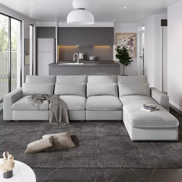 Canva Home oversized linen fabric L-shape sectional sofa with four pillows, 129 inches wide and 1100 lb capacity, in a modern living room.