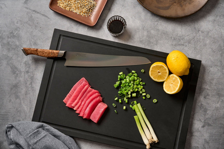 Steelport Knife Co. 10-inch slicing kitchen knife with sharp blade on cutting board for precise meat and vegetable slicing.