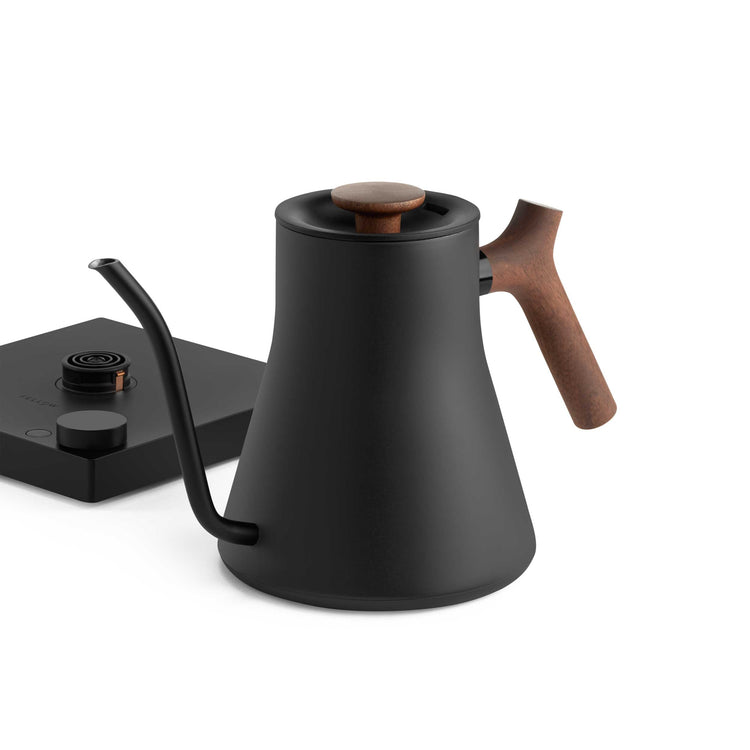 Fellow Stagg EKG Pro electric kettle in matte black with walnut handle, showing the sleek spout and control panel.