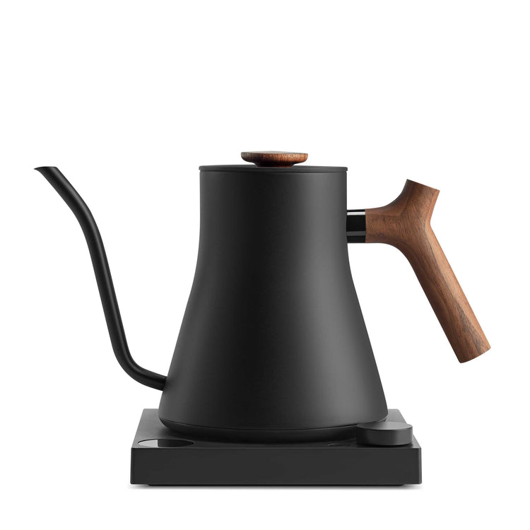 Fellow Stagg EKG Pro electric kettle in matte black with walnut handle, sleek design, and digital display for precise pouring.