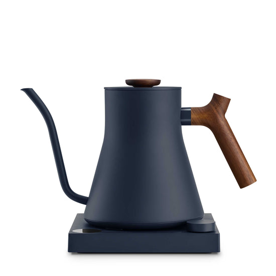Fellow Stagg EKG Pro electric kettle in stone blue with walnut handle, showcasing its sleek design and digital control panel.