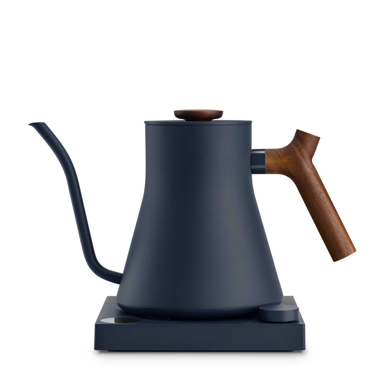 Fellow Stagg EKG Pro electric kettle in stone blue with walnut handle, showcasing its sleek design and digital control panel.