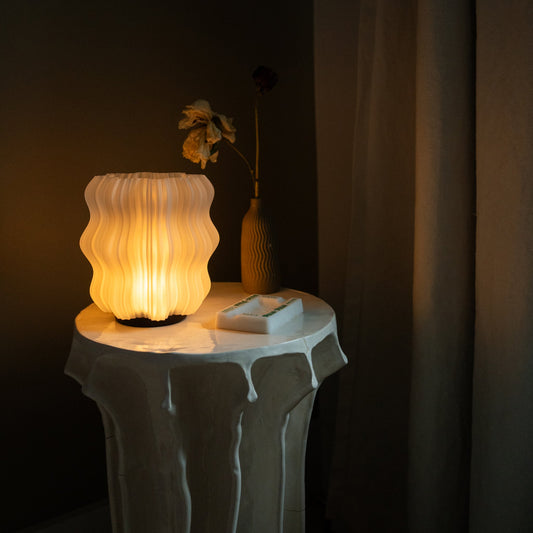 Wooj Design cordless mini wavy 3D printed table lamp with amber glow, modern rechargeable design, and sleek wavy shape.