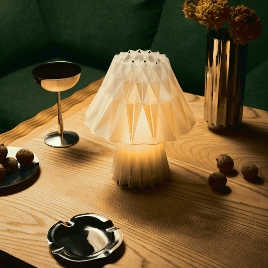 Wooj Design Prisma Lamp with geometric, multi-faceted glass shade emitting soft, colorful light for modern home décor.