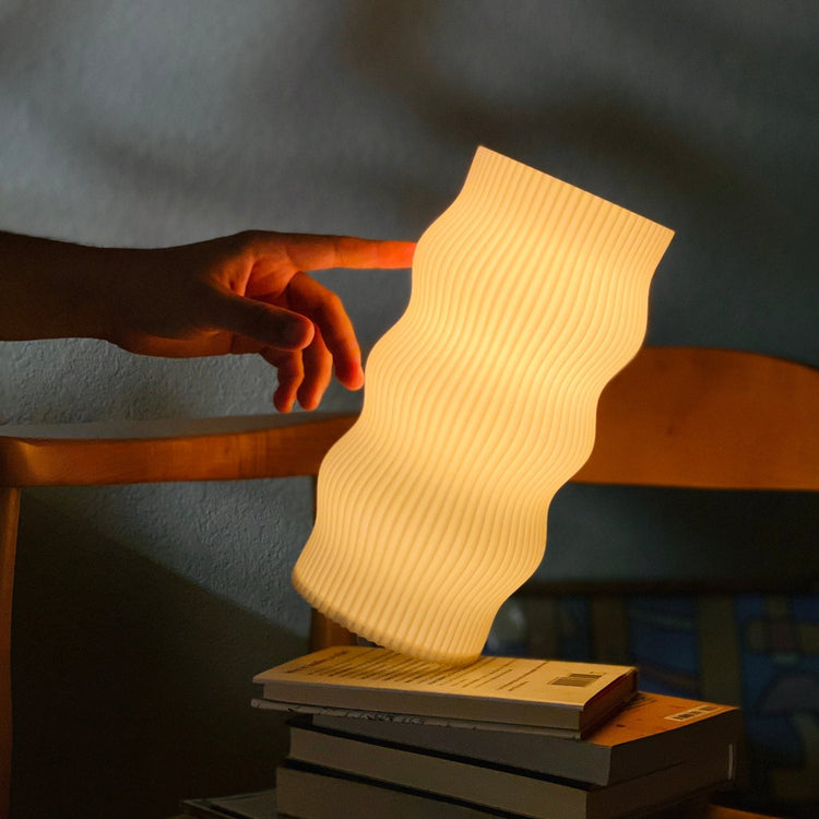 Modern Terra Labs Wub Table Lamp with a sleek, minimalist design and soft ambient lighting on a wooden surface.