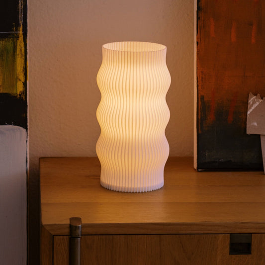 Terra Labs Wub Table Lamp with a modern design, featuring a sleek base and a rounded, colorful lampshade on a wooden surface