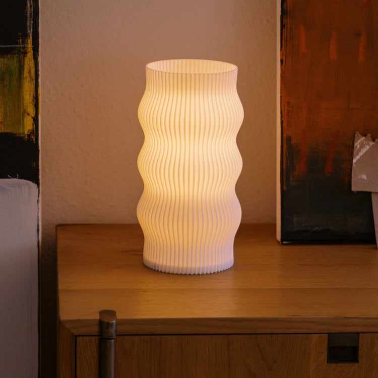 Terra Labs Wub Table Lamp with a modern design, featuring a sleek base and a rounded, colorful lampshade on a wooden surface